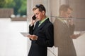 Young business man using digital tablet computer and calling on cell phone Royalty Free Stock Photo