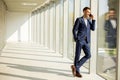 Young business man using mobile phone in the modern office hallway Royalty Free Stock Photo