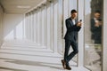 Young business man using mobile phone in the modern office hallway Royalty Free Stock Photo