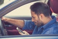 Young business man using texting on mobile phone while driving a car Royalty Free Stock Photo