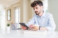 Young business man using touchpad tablet with a confident expression on smart face thinking serious Royalty Free Stock Photo