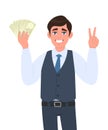 Young business man in waistcoat showing cash, currency notes and gesturing victory, peace,  two sign. Trendy person holding money. Royalty Free Stock Photo