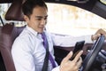Young business man watching mobile phone in the car Royalty Free Stock Photo