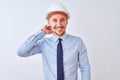 Young business man wearing contractor safety helmet over isolated background confuse and wonder about question Royalty Free Stock Photo