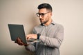 Young business man wearing glasses working using computer laptop with a confident expression on smart face thinking serious Royalty Free Stock Photo