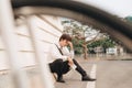 Young business man who lost job abandoned lost in depression sitting on ground street subway suffering emotional pain, thinking