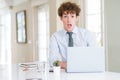 Young business man working with computer laptop at the office afraid and shocked with surprise expression, fear and excited face Royalty Free Stock Photo