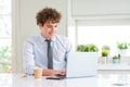 Young business man working with computer laptop at the office with a happy face standing and smiling with a confident smile Royalty Free Stock Photo