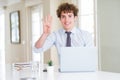 Young business man working with computer laptop at the office showing and pointing up with fingers number four while smiling Royalty Free Stock Photo