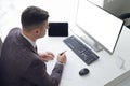 Young business man working at the computer and papers on the table