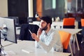 Young business man working on desktop computer at his desk in modern bright startup office interior Royalty Free Stock Photo