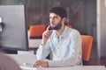 Young business man working on desktop computer at his desk in modern bright startup office interior Royalty Free Stock Photo