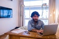 Young business man working at home in his bedroom with laptop and papers on desk. Home office concept Royalty Free Stock Photo