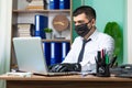 Young business man working on laptop with black medical protective mask and gloves Royalty Free Stock Photo