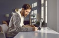 Young business man working with laptop computer at home or at office and writing. Royalty Free Stock Photo