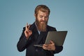 Man working on a laptop giving peace victory hand gesture