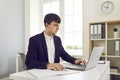 Young business man working on a laptop at office and looking on a computer screen. Royalty Free Stock Photo