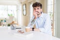 Young business man working looking stressed and nervous with hands on mouth biting nails Royalty Free Stock Photo