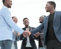 Young business partners shaking hands to applause of employees Royalty Free Stock Photo