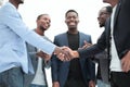 Young business partners shaking hands to applause of employees Royalty Free Stock Photo