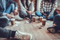 young business people in casual clothes are discussing work, drinking coffee and smiling while sitting on the floor in office