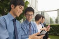Young business people checking their cell phones and smiling Royalty Free Stock Photo