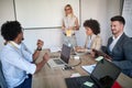 Young business people in conference room with laptops, cell phones whiteboard in the background. conference, meeting, business Royalty Free Stock Photo