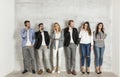 Young business people with mobile phone standing by the wall Royalty Free Stock Photo