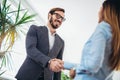 Young business people shaking hands in the office. Royalty Free Stock Photo