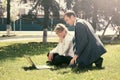 Young business people using laptop in city park Royalty Free Stock Photo