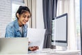 Young business smiling happy asian woman working holding a piece of paperwork and reading while standing in front of laptop Royalty Free Stock Photo