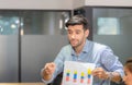 Young business team of coworkers meeting in creative office, businessman holding paper and sitting on table, Teamwork concept Royalty Free Stock Photo