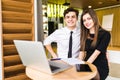 Young business team working together at a laptop smiling as they see their project come to fruition, man and woman Royalty Free Stock Photo