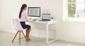 Young business woman accountant working on a laptop with tables at modern white office. Royalty Free Stock Photo