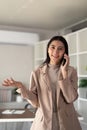 Young business woman asian talking on mobile phone while working with laptop at desk home Royalty Free Stock Photo