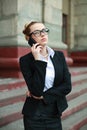 Young business woman in black suit and glasses talking on phone Royalty Free Stock Photo