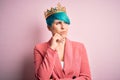 Young business woman with blue fashion hair wearing queen crown over pink isolated background with hand on chin thinking about Royalty Free Stock Photo