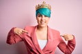 Young business woman with blue fashion hair wearing queen crown over pink isolated background looking confident with smile on Royalty Free Stock Photo