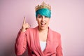 Young business woman with blue fashion hair wearing queen crown over pink isolated background pointing finger up with successful Royalty Free Stock Photo