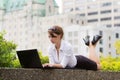 Young business woman casualy works on laptop in the city