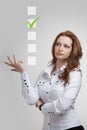 Young business woman checking on checklist box. Gray background. Royalty Free Stock Photo