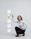 Young business woman checking on checklist box. Gray background. Royalty Free Stock Photo