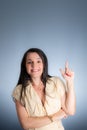 Young business woman, cheerful, pointing her left finger up Royalty Free Stock Photo