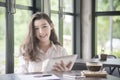 Young business woman cheerful smile sitting at coffee time in cafe, enjoying online communication using free wireless internet Royalty Free Stock Photo