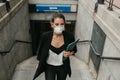 Young business woman comes out of the subway with a medical mask Royalty Free Stock Photo