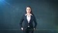 Young business woman dress in black suit and white shirt is standing, holding her hands on hips. Royalty Free Stock Photo