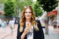 Young business woman eating ice cream. Happy alone woman in in the city on sunny summer day, break for lunch between Royalty Free Stock Photo
