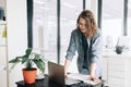 Young Business Woman Embracing Productivity: Using Laptop Computer at Office. Student Girl Thriving in a Modern Royalty Free Stock Photo