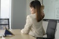 Young business woman feeling pain in neck and back in modern office