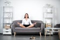 Young business woman freelancer or ceo employee doing yoga exercise on sofa at workplace in a modern office. Employee Royalty Free Stock Photo